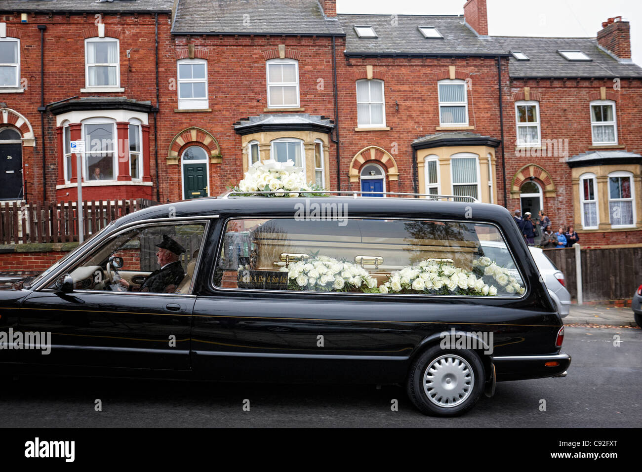 LEEDS, UK, 09/11/2011 13:45 The gold coloured coffin of Sir Jimmy Savile passes his childhood home, 22 Consort Terrace, Woodhouse Leeds before  a funeral at St Anne’s Cathedral, Leeds. Sir Jimmy, a popular broadcaster and charity worker, died at his home in Roundhay, Leeds, on 29 October, he was 84. Stock Photo