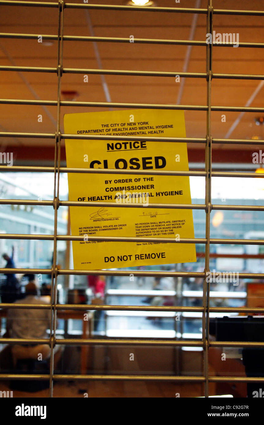 Gated eatery with yellow inspection notice of closing by Department of