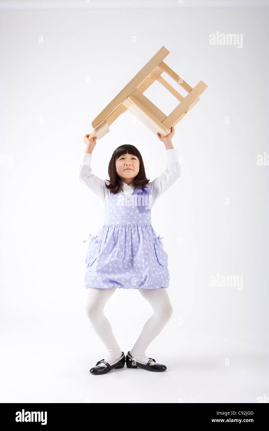 A girl holding chair above her head Stock Photo Alamy