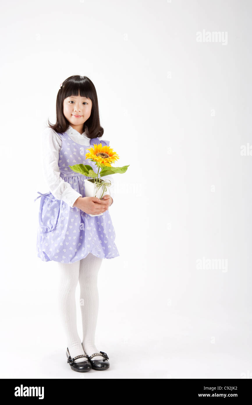 A girl holding potted flower plant, portrait Stock Photo - Alamy