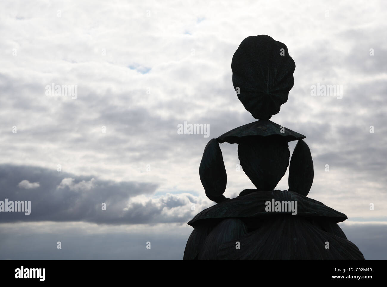 Silhouette of a giant sized statue of a lady made from shells