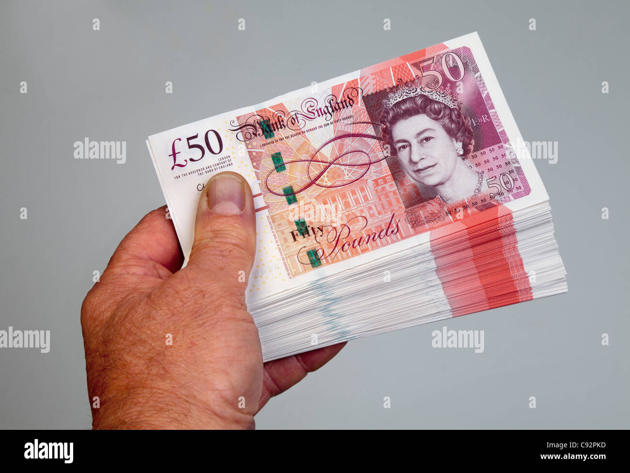 50 pound British currency bank notes £50 cash held in male hand Stock Photo