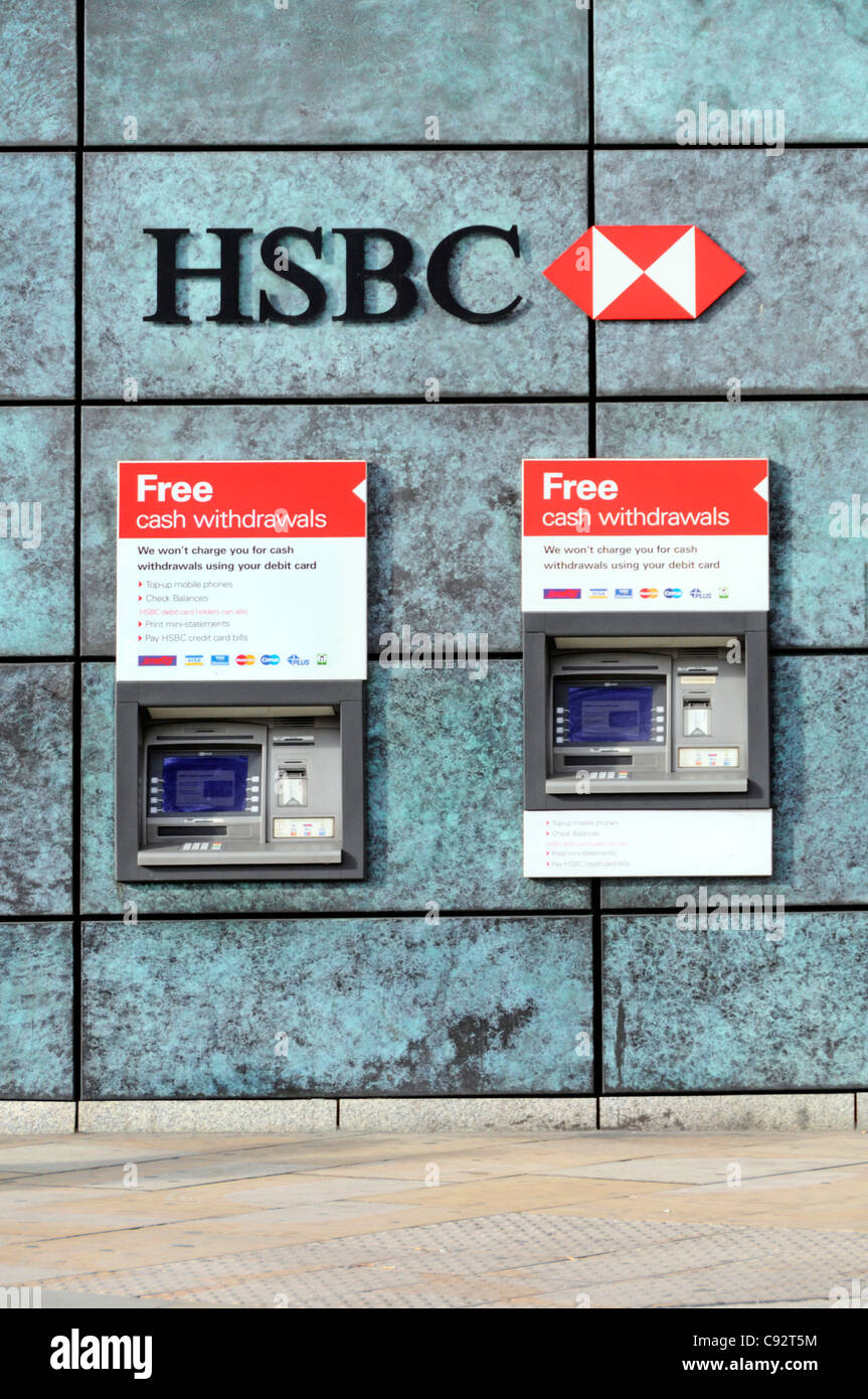 Two HSBC bank ATM cash machines free withdraw cash from a hole in wall of bank premises below bank sign and logo in City of London England UK Stock Photo