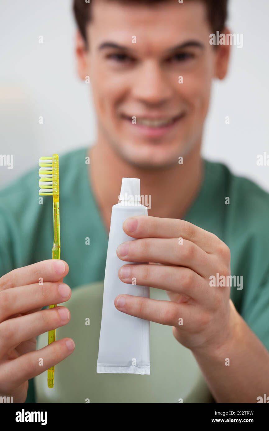 Portrait of dentist holding toothpaste and toothbrush Stock Photo
