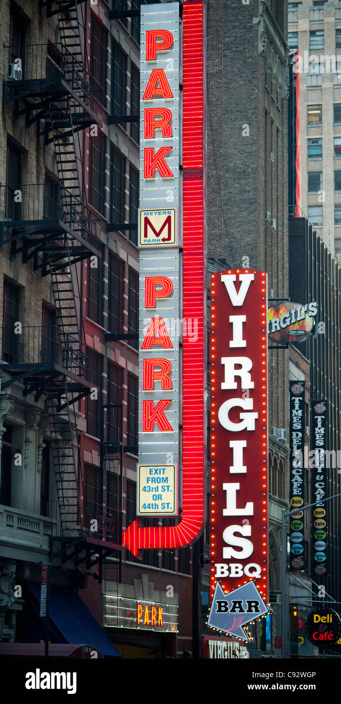 Illuminated signs for Virgils BBQ and a parking garage in Times Square in New York Stock Photo