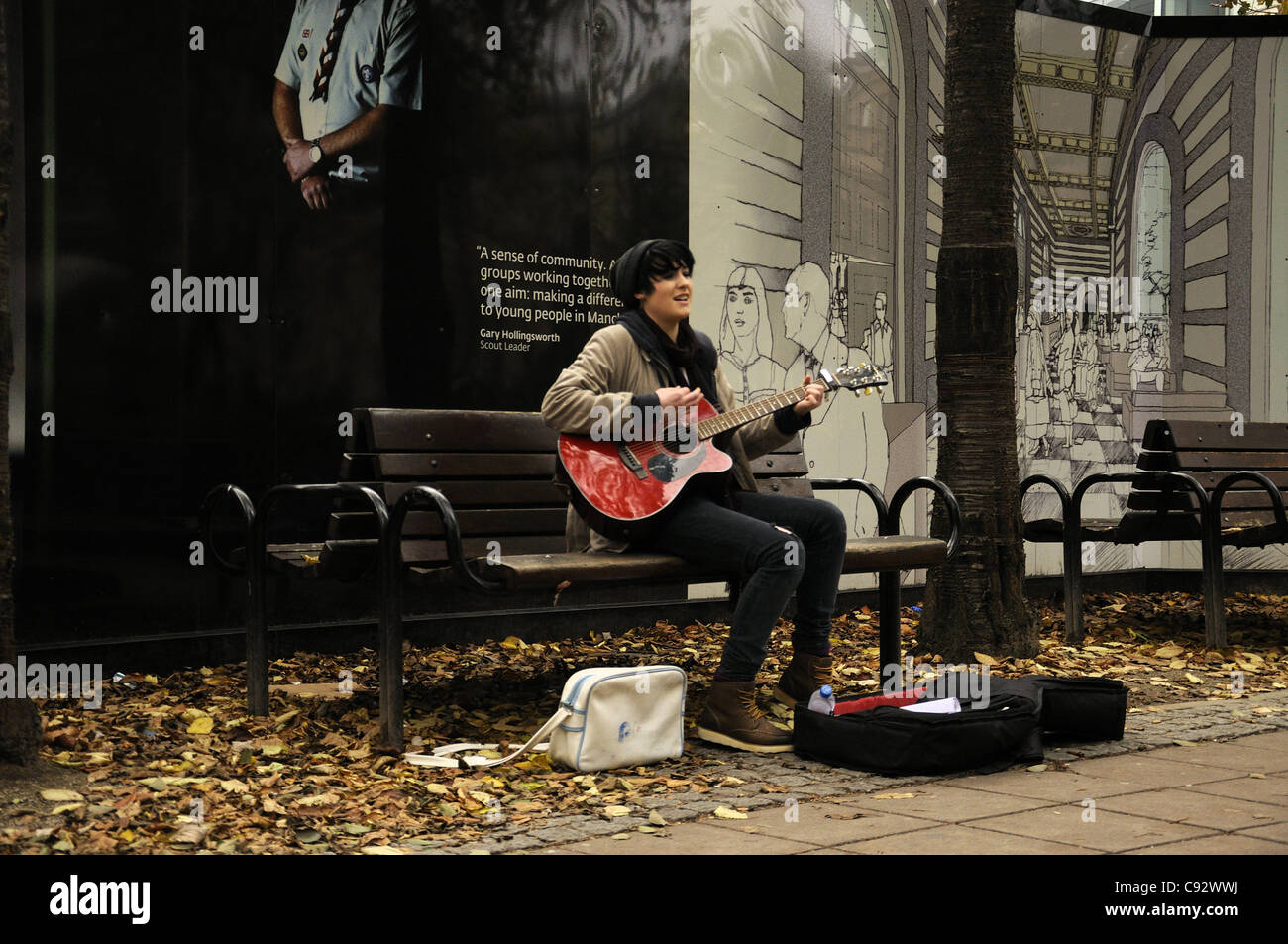 Female busker with guitar in Manchester Stock Photo - Alamy