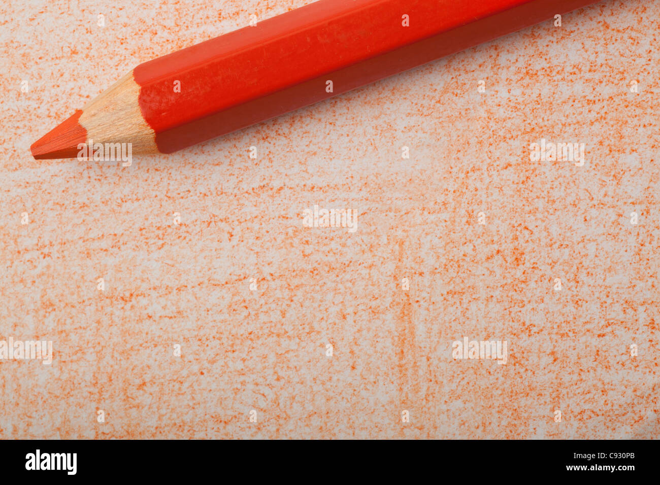 Orange color pencil with coloring on a piece of paper Stock Photo