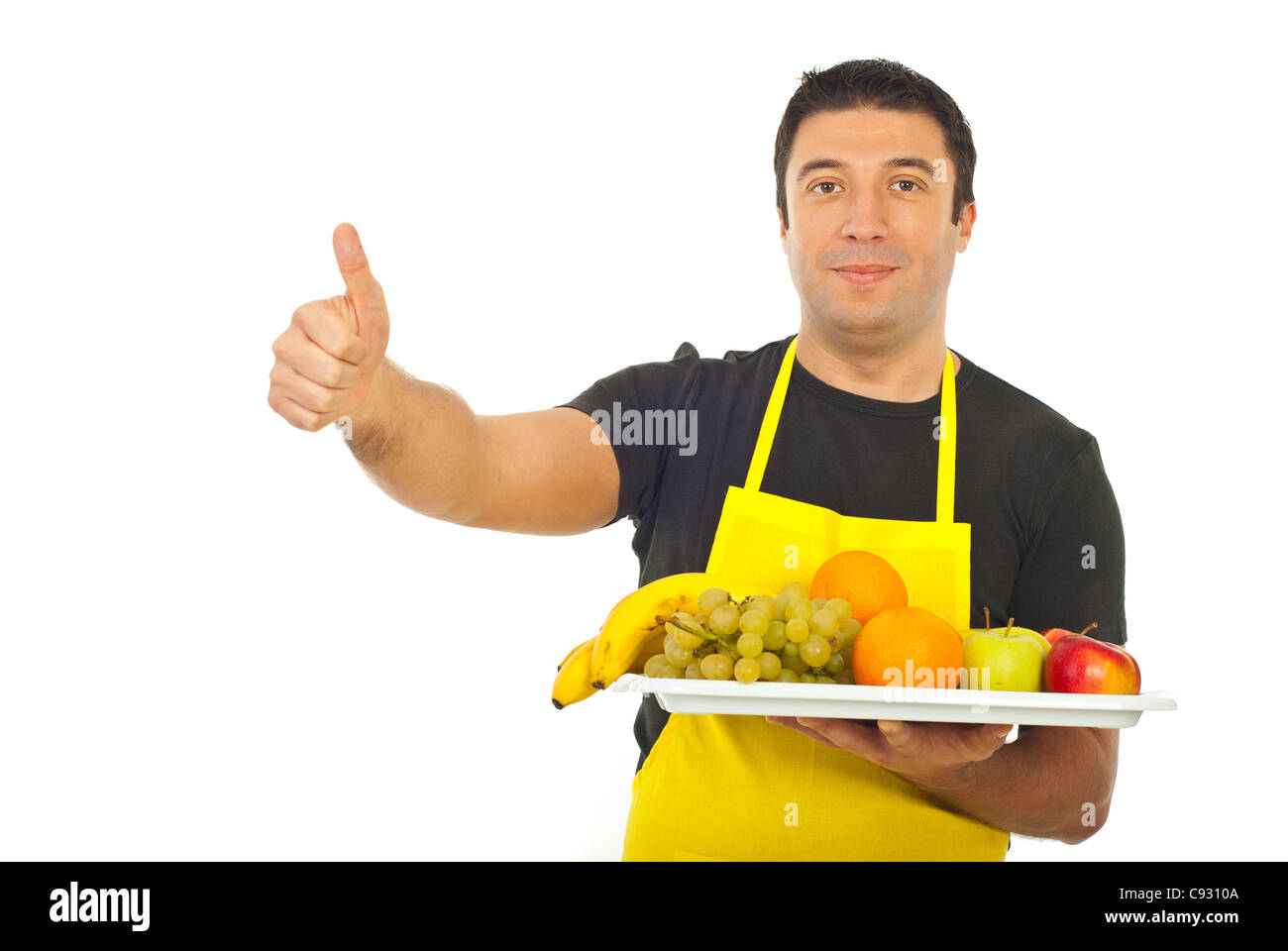 Successful fruiterer worker holding fruits and giving thumbs up isolated on white background Stock Photo