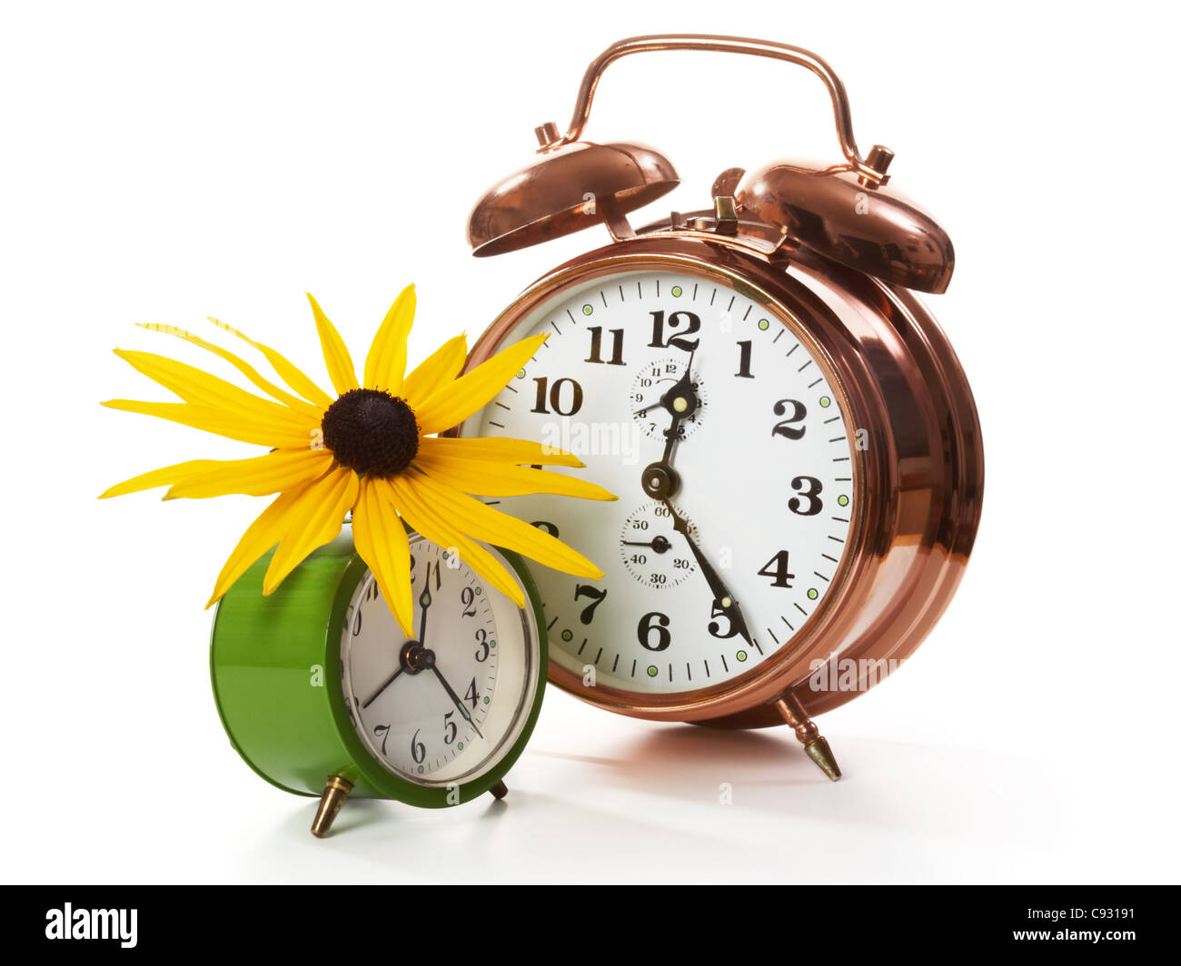 Two alarm clocks with sunflower on white Stock Photo - Alamy