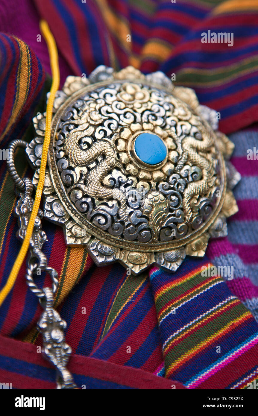 The beautiful shoulder clasp of a Bhutanese woman wearing national dress called kira. Stock Photo