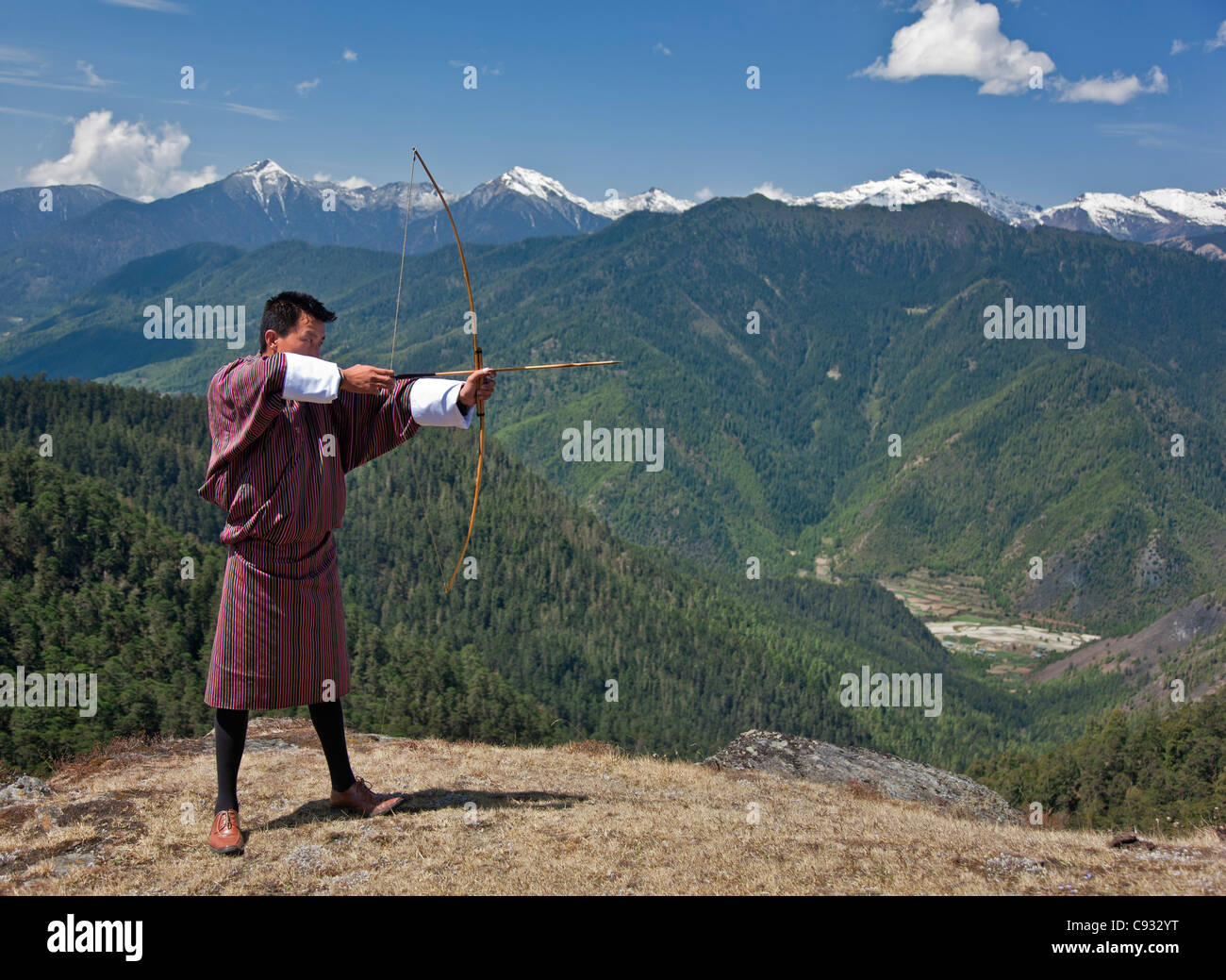 Archery, datse, is a favourite national sport of the Bhutanese. Here an Archer practices his skills on the high Cheli La Pass. Stock Photo