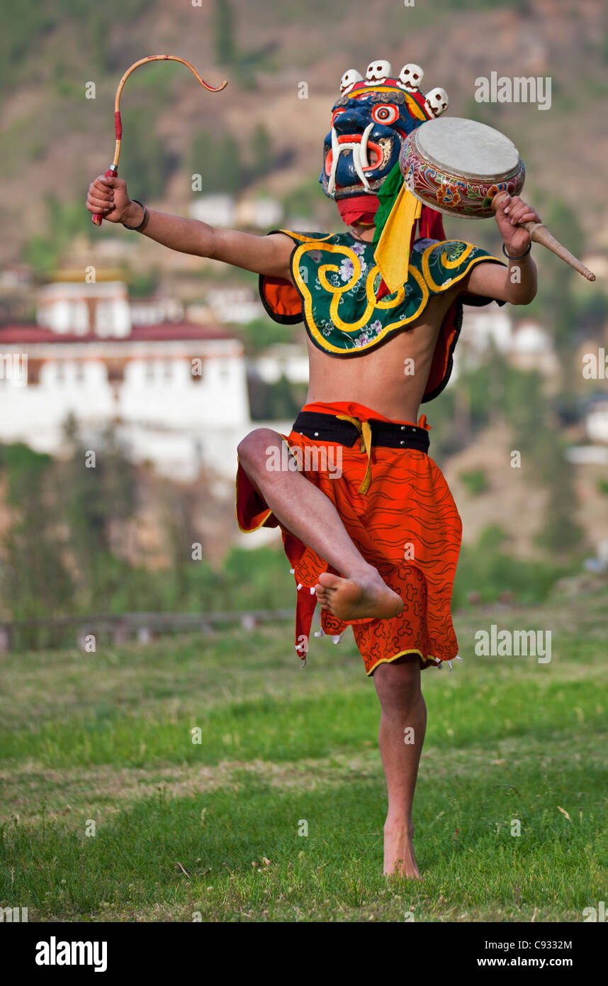 A dancer performs Ging dang Tsoling, the Dance of Ging and the Tsholing outside Punakha Dzong. Stock Photo