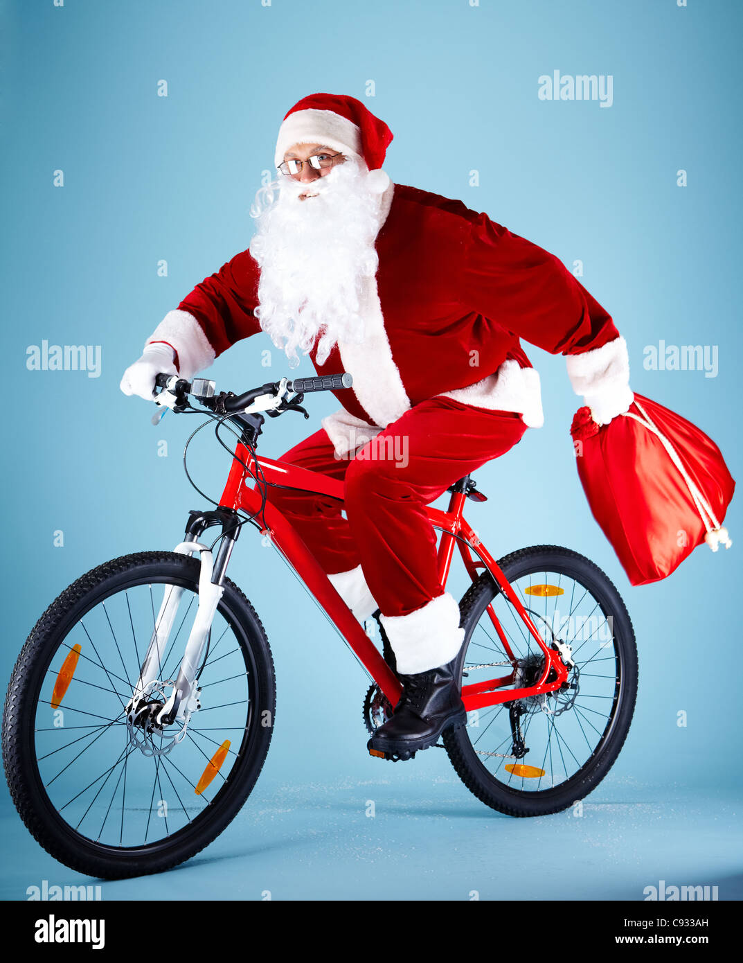 Photo of Santa Claus with red sack riding bike Stock Photo - Alamy