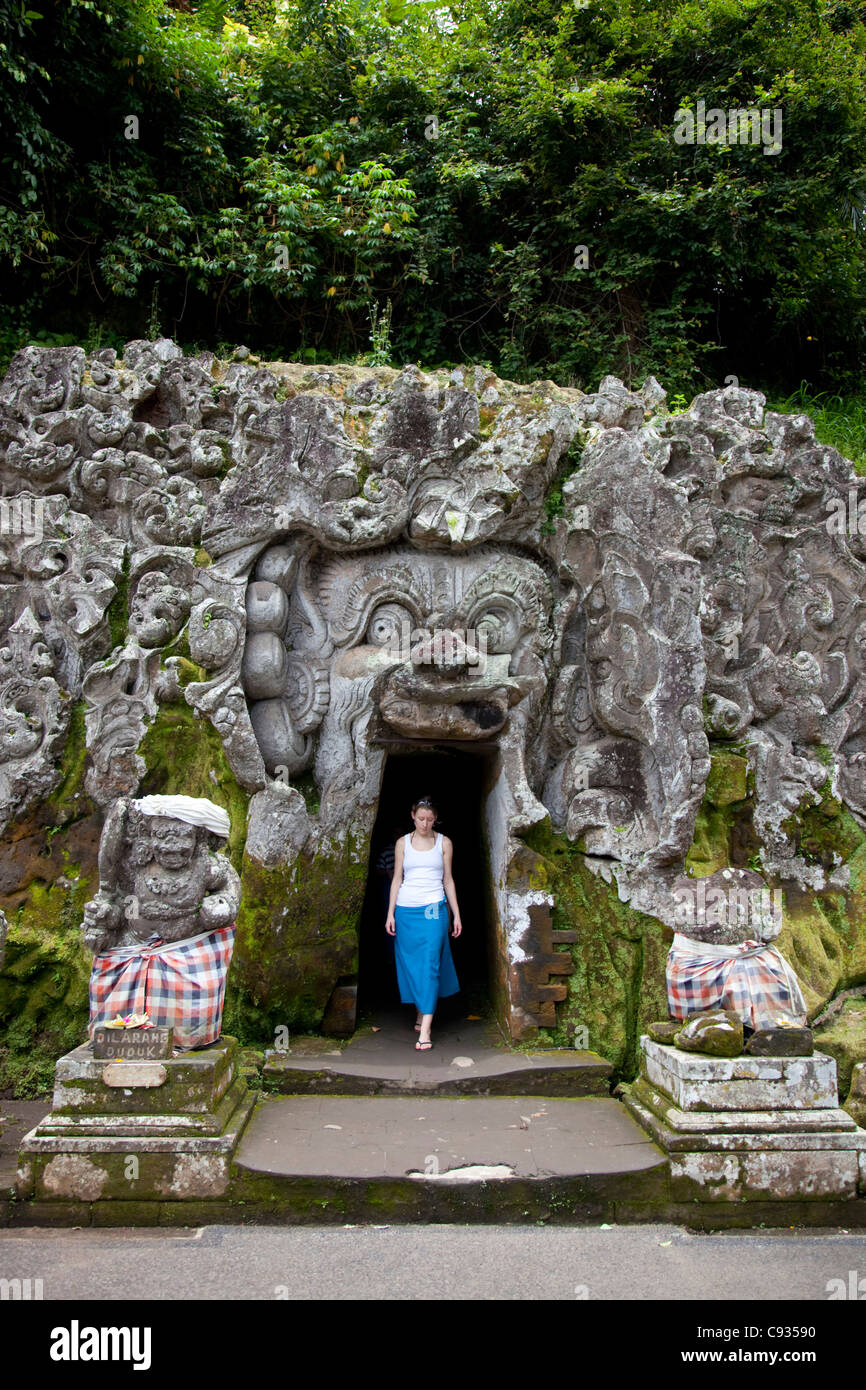 Bali, Ubud. A young woman emerges from exploring one of the shrines at the Goa Gajah Elephant Caves near Ubud. MR Stock Photo