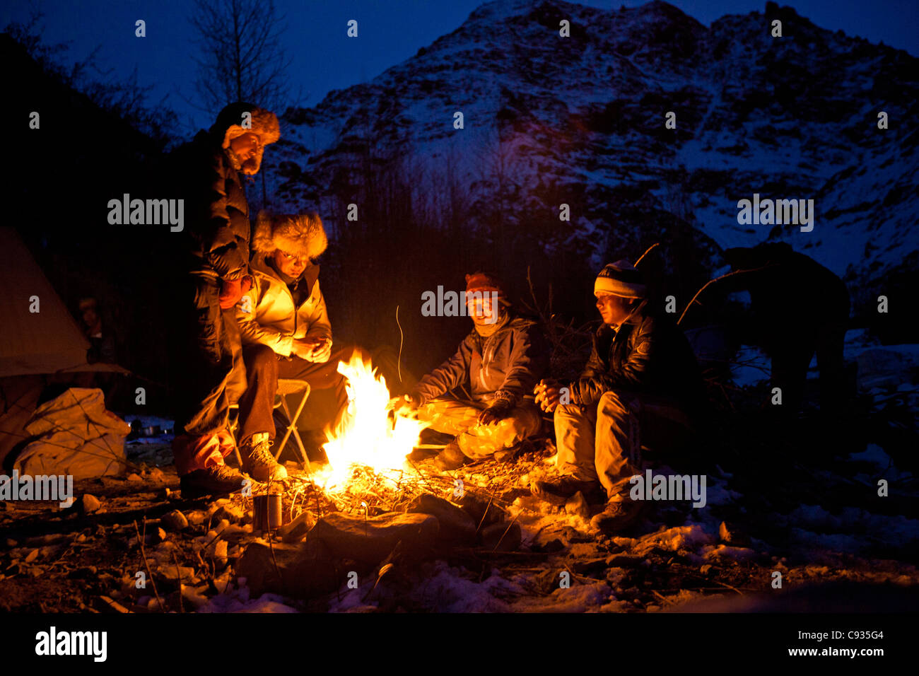 India, Ladakh, Rumbak. Warding off the Himalayan night chill around the camp fire in the Rumbak Valley, Ladakh, India Stock Photo