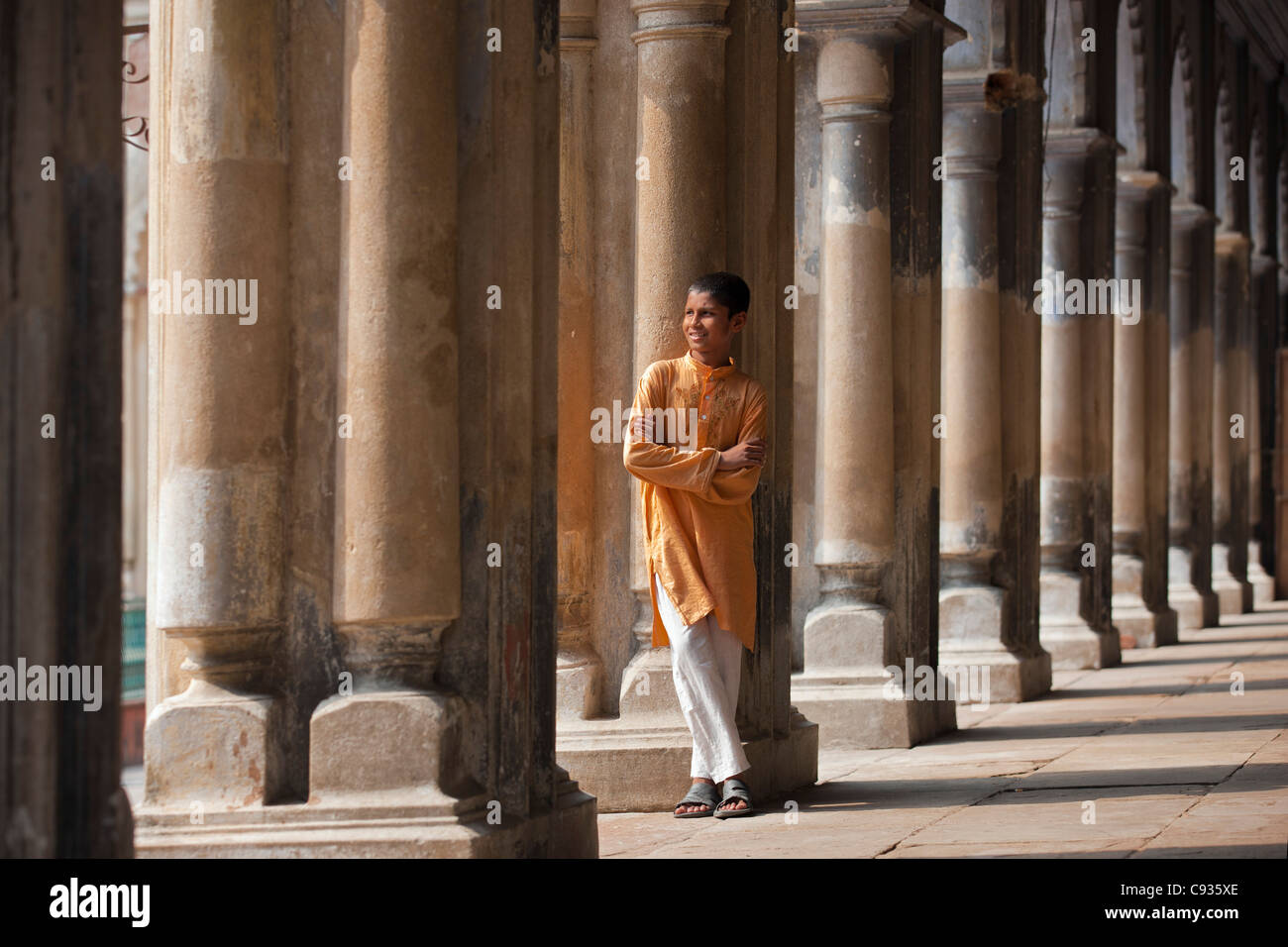 A student relaxes beside the pillars of the impressive Hugli Imambara building. Stock Photo
