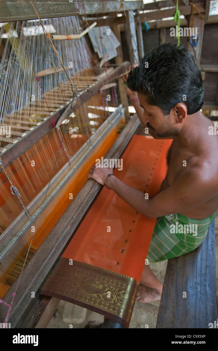 A man weaves a beautiful sari on a traditional wooden loom at Santipur village on the banks of the Hooghly River. Stock Photo