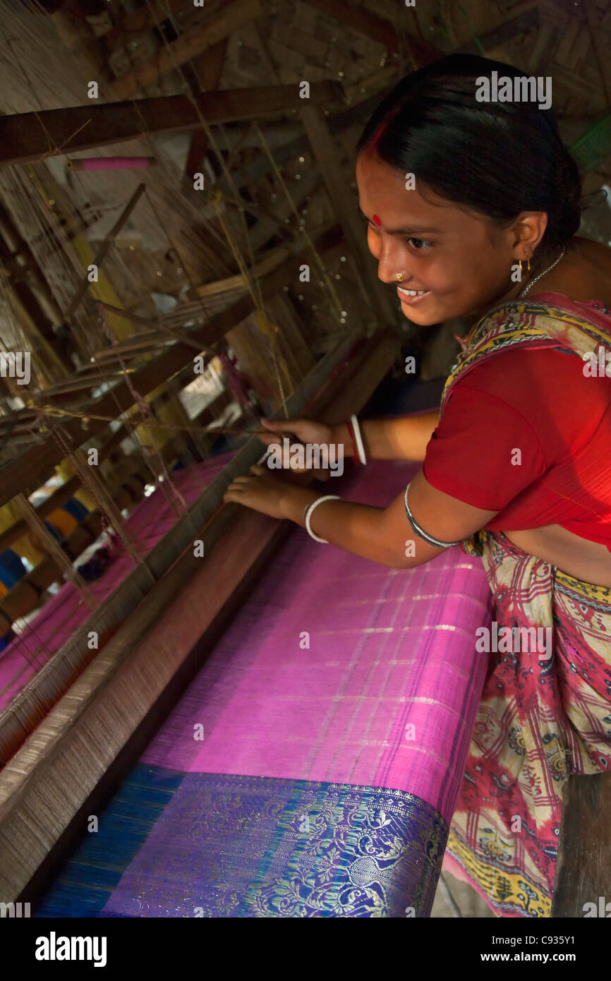 A woman weaves a beautiful sari on a traditional wooden loom at Santipur village on the banks of the Hooghly River. Stock Photo