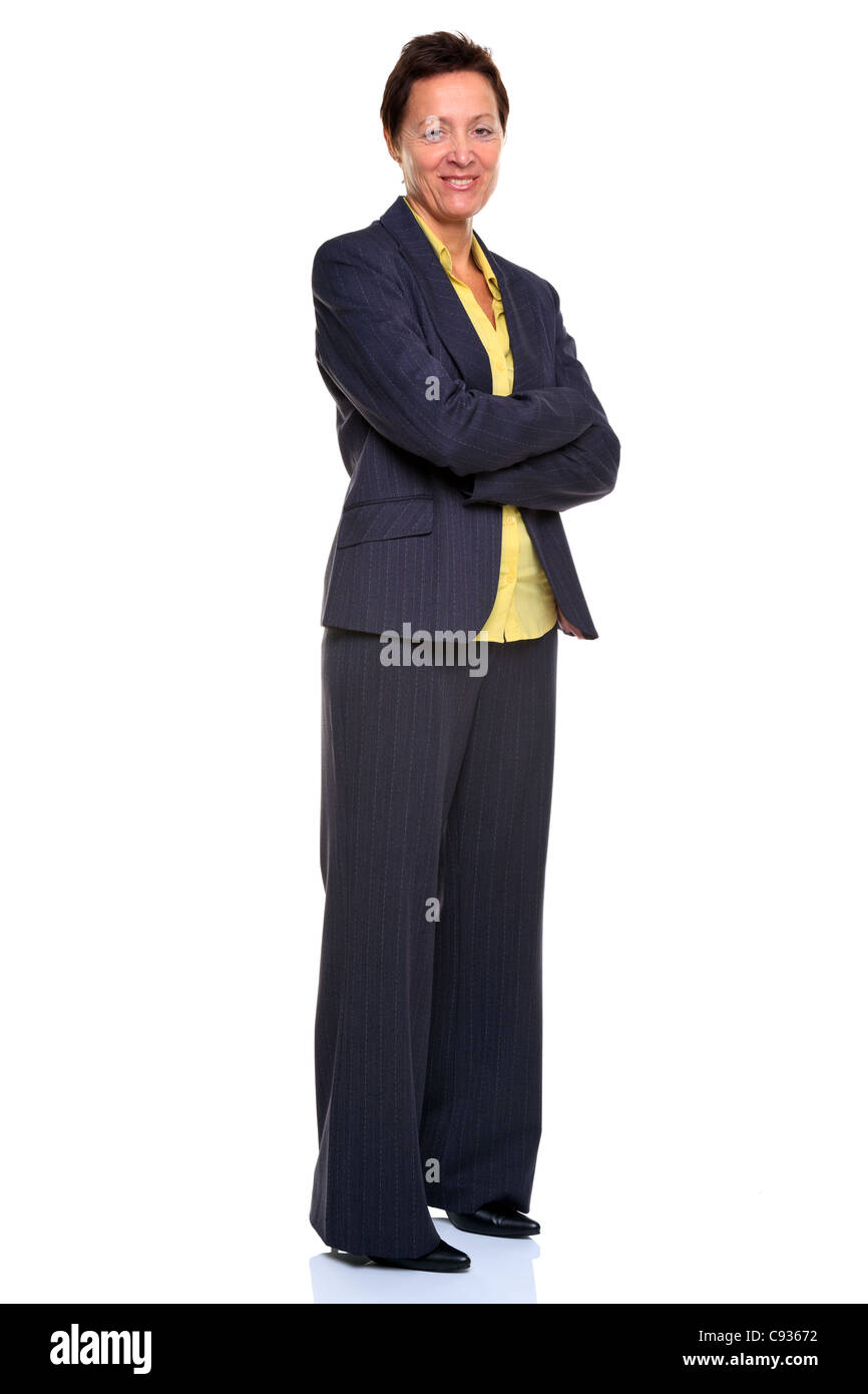 Photo of a mature businesswoman with her arms folded stood sideways smiling to camera Stock Photo