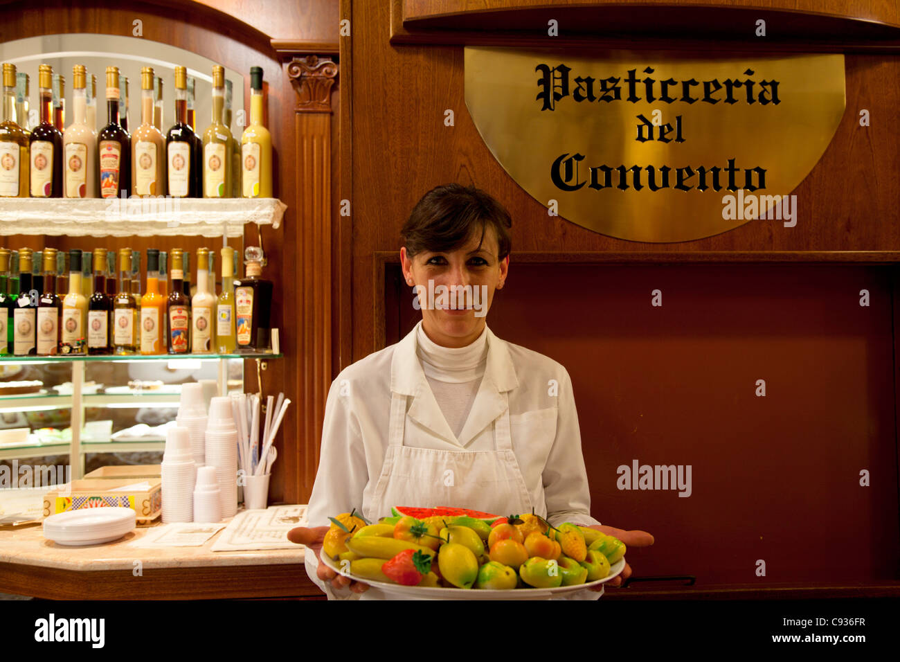 Sicily, Italy,  The proud owner of a sweet shop holding a plate of Marzipan fruits Stock Photo