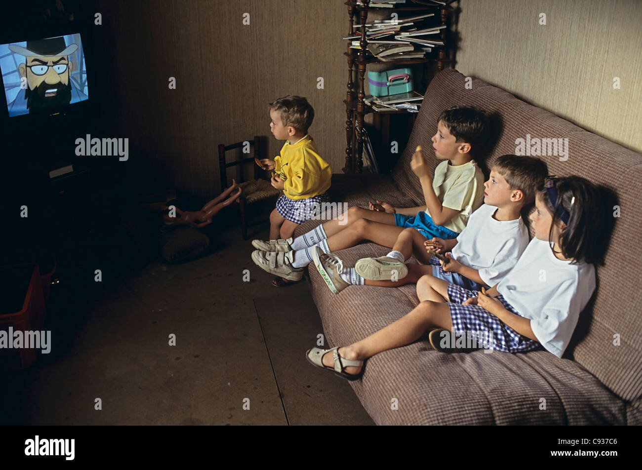 4 young brothers and sisters watching tintin on tv in France Stock