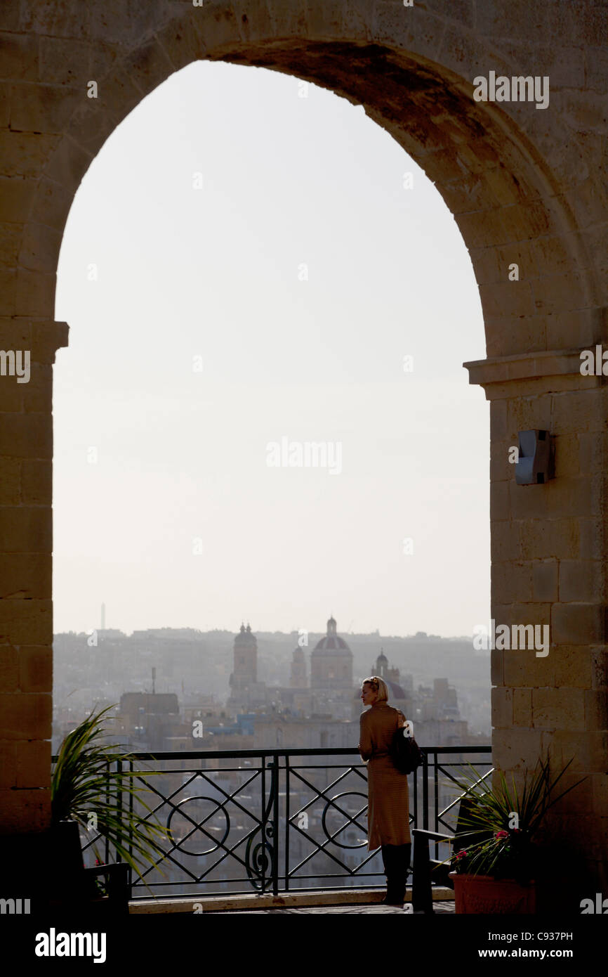 Malta, Europe; A tourist enjoying the scenery of the three cities from the Upper Barracca Gardens in Valletta Stock Photo
