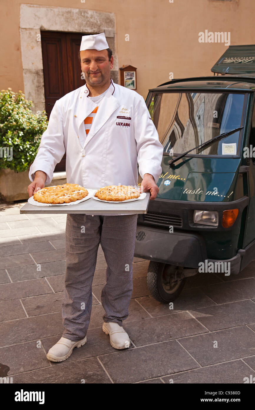 Italy, Marches Region, Visso. The local baker with his pastries and his classic Ape 50 delivery van. Stock Photo