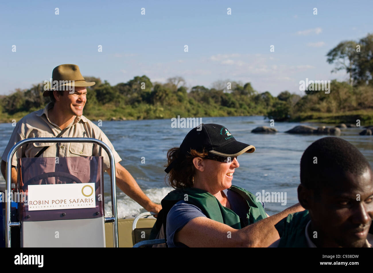 Malawi, Majete Wildlife Reserve. A guide with Robin Pope Safaris drives a speedboat game viewing along the Shire River. Stock Photo