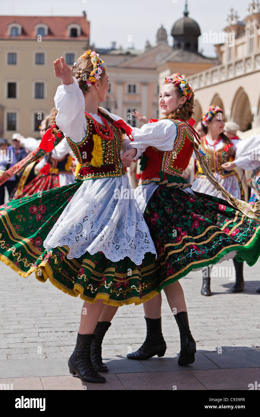 Poland, Cracow. Polish girls in traditional dress dancing in Market Square. Stock Photo