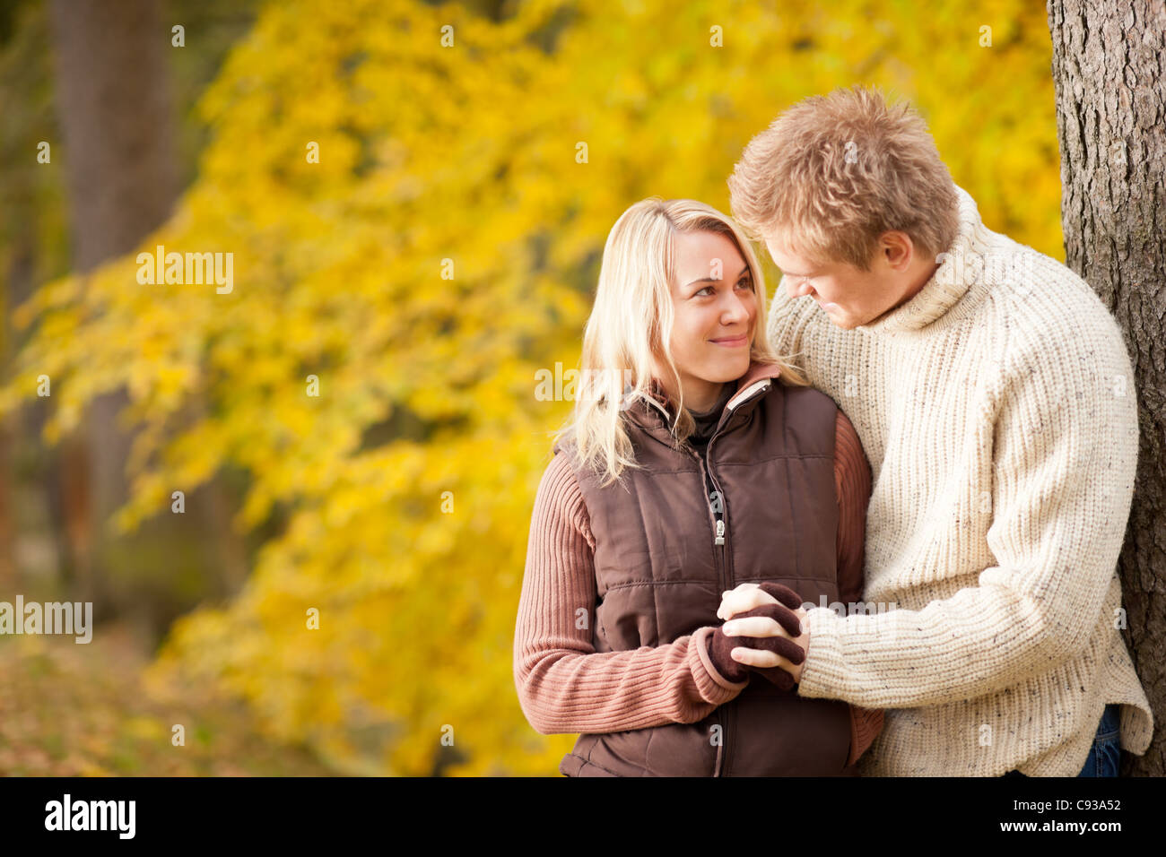 Smiling young couple in love hugging in autumn park together Stock ...