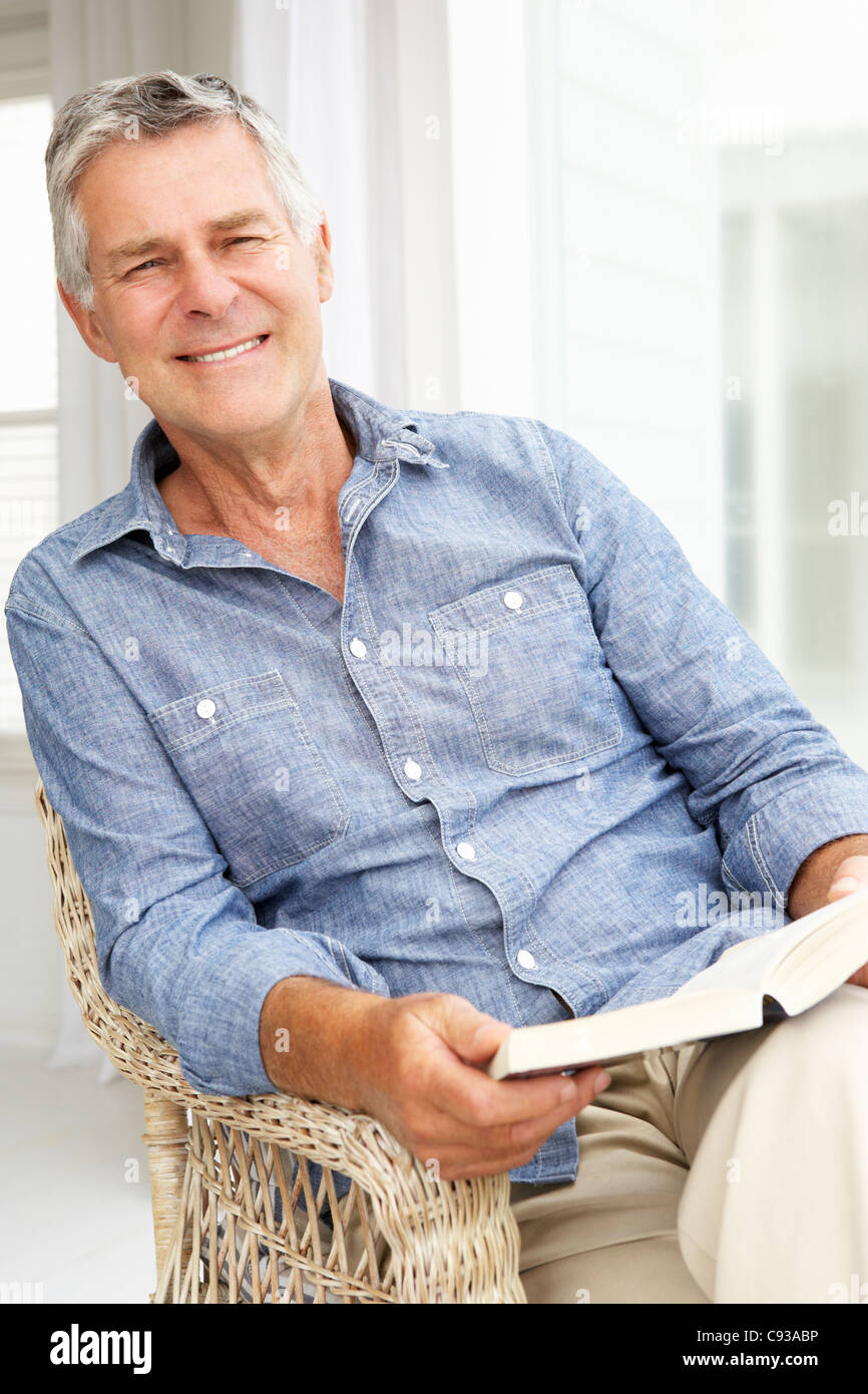 Senior man relaxing at home with a book Stock Photo - Alamy