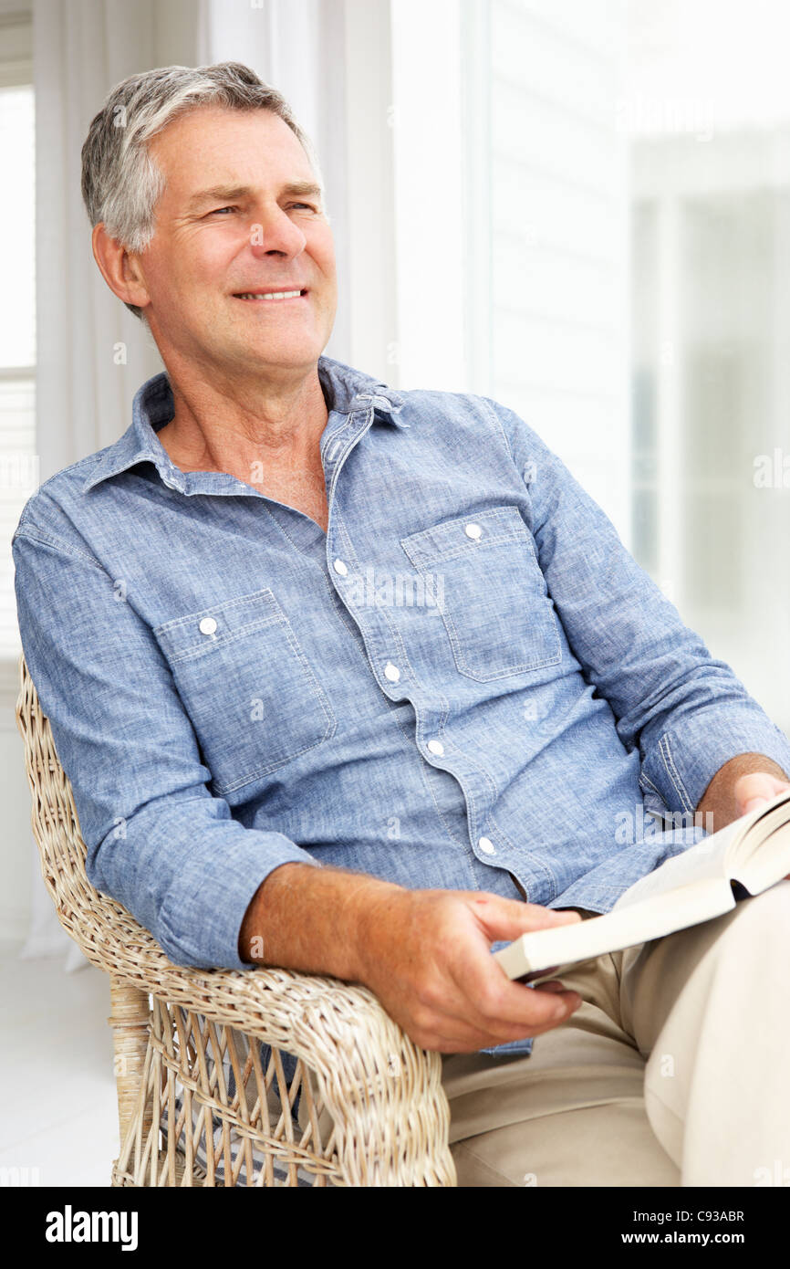 Senior man relaxing at home with a book Stock Photo - Alamy