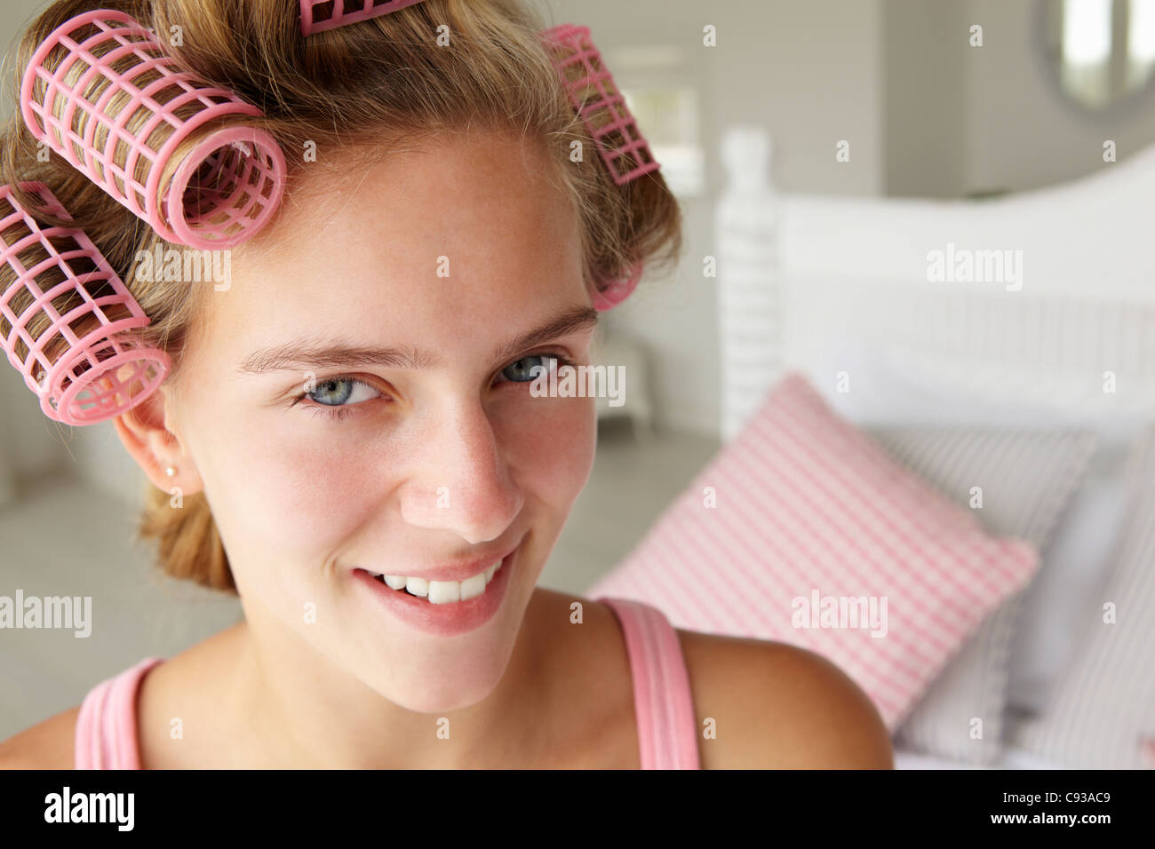 Teenage girl with hair in curlers Stock Photo