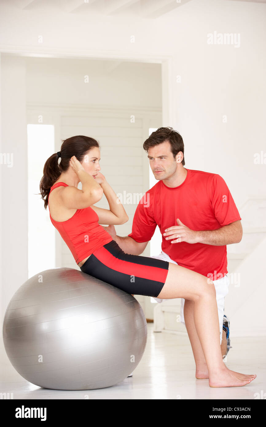 Woman with personal trainer in home gym Stock Photo