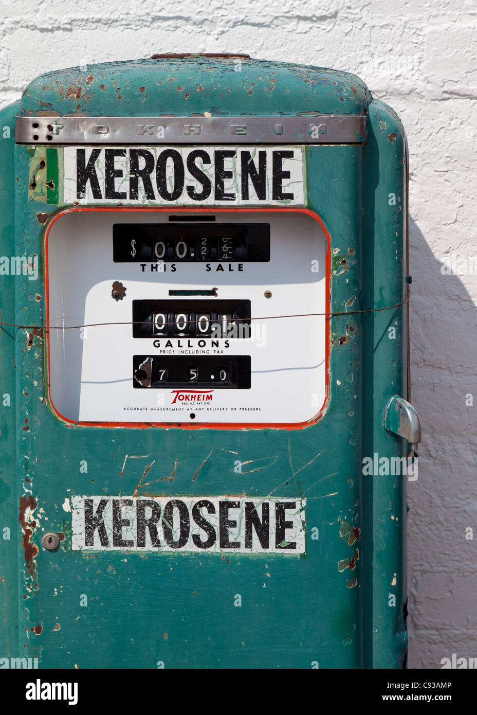 The front of an old, rusting green retro kerosene petrol pump on a