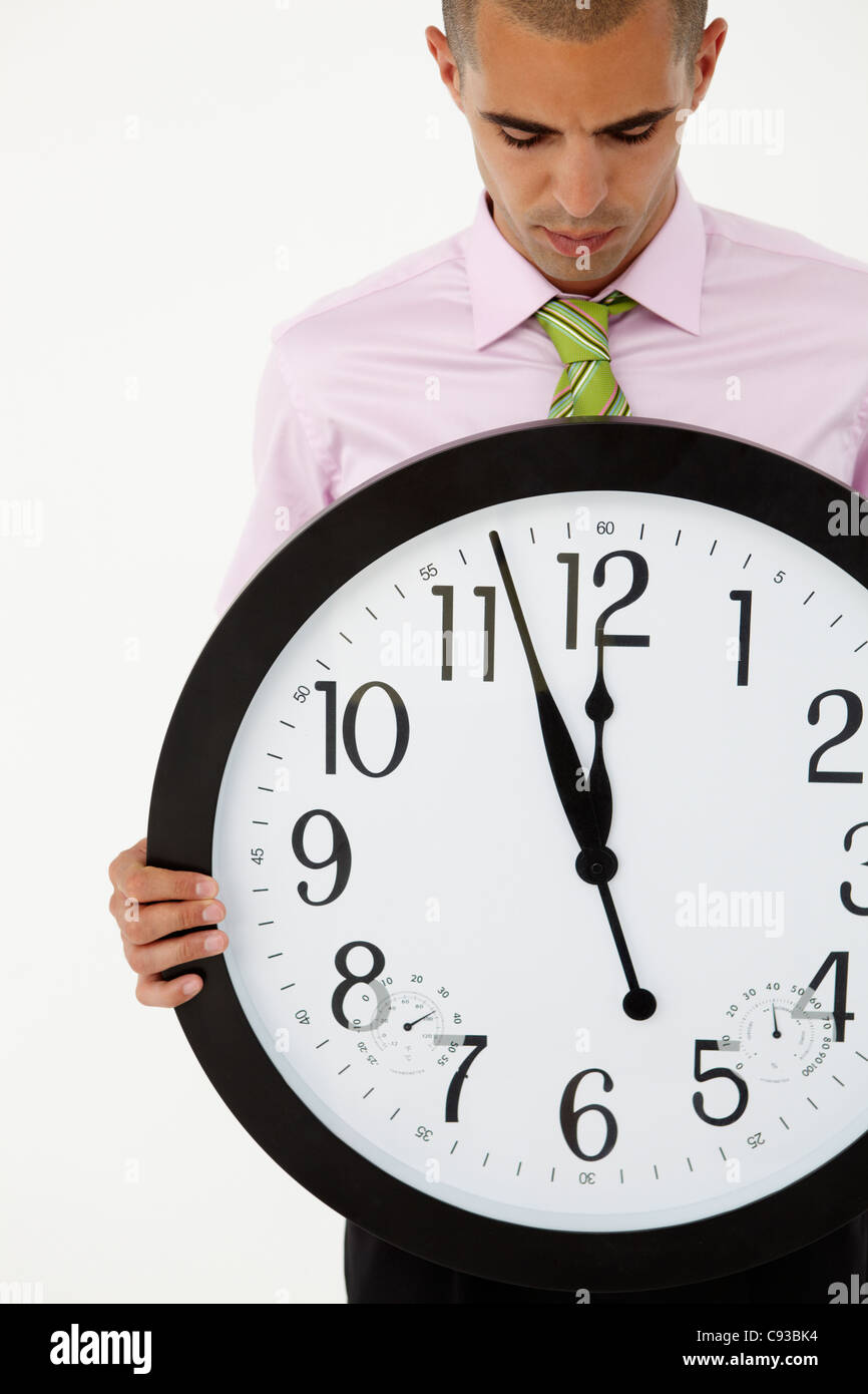 Young businessman with giant clock Stock Photo