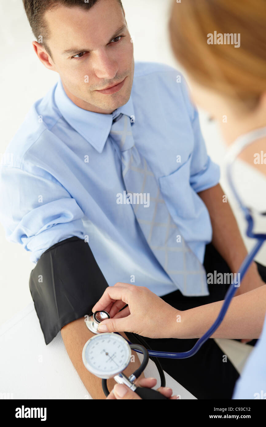 Young man having blood pressure taken Stock Photo