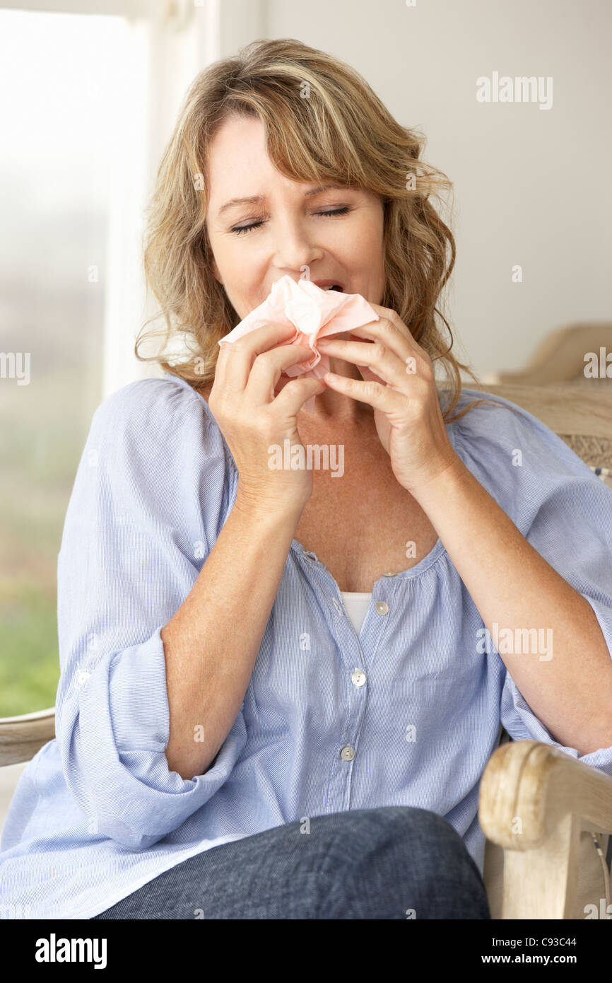 Mid age woman sneezing Stock Photo
