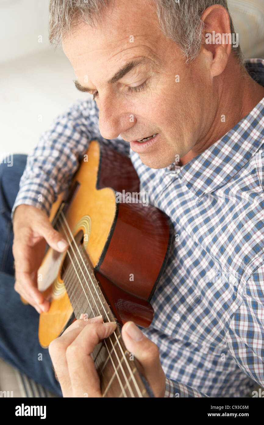 Mid age man playing acoustic guitar Stock Photo