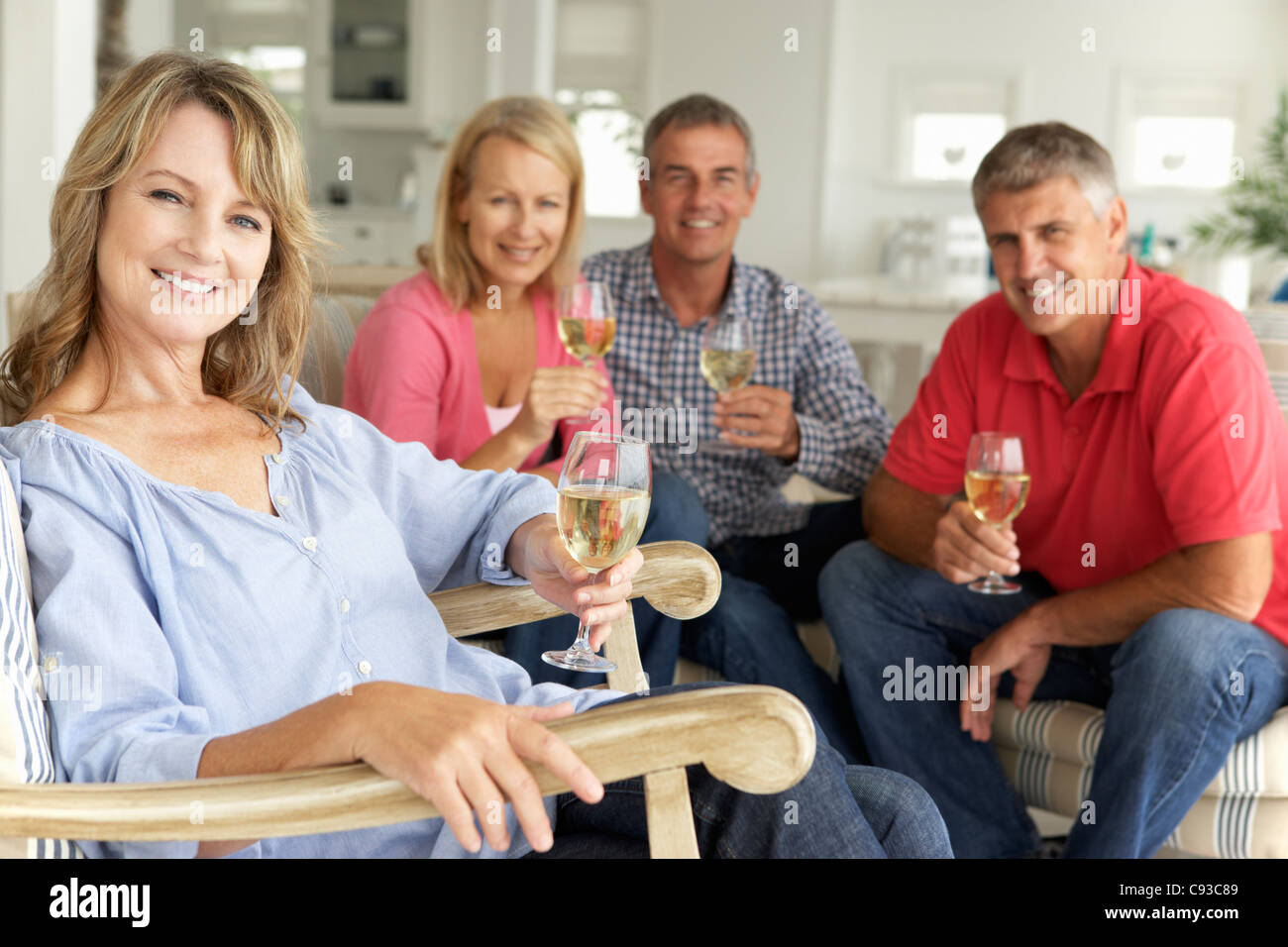 Mid age couples drinking together at home Stock Photo