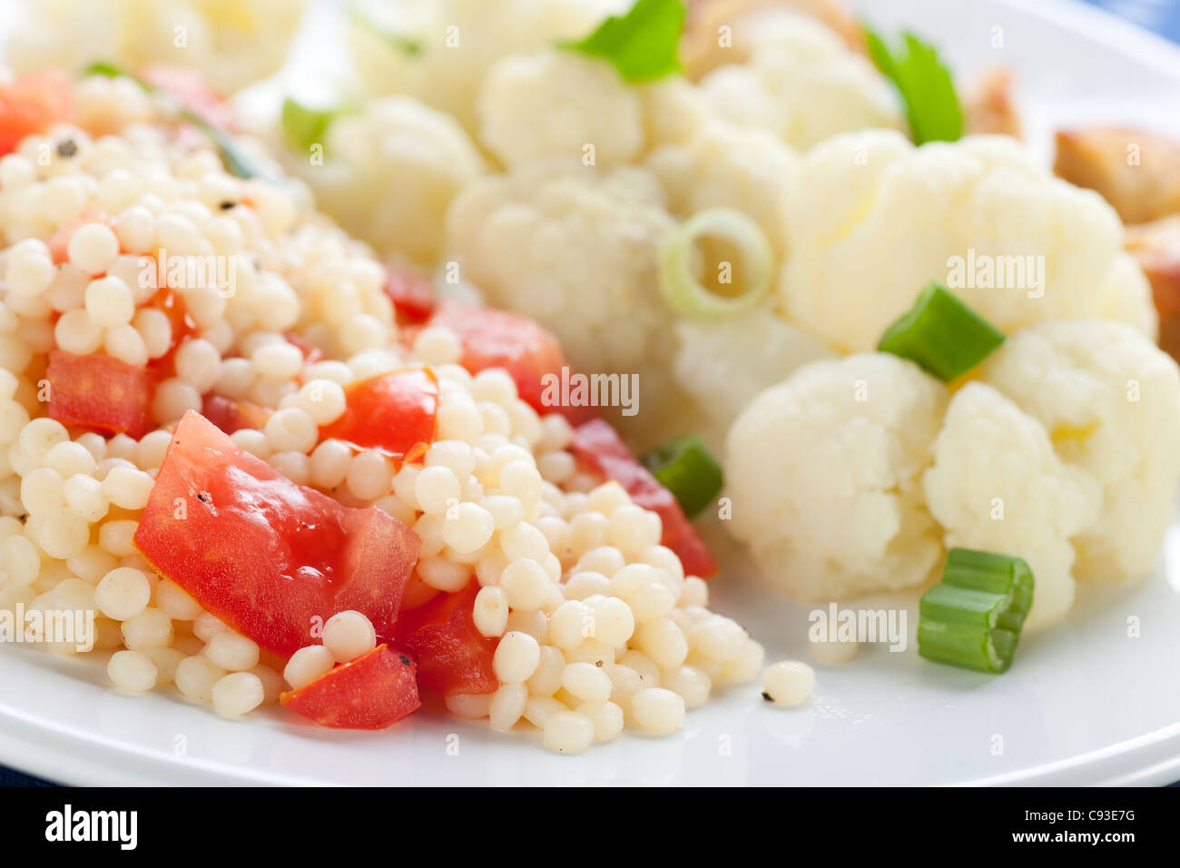 Couscous with tomatoes and fresh steamed cauliflower Stock Photo