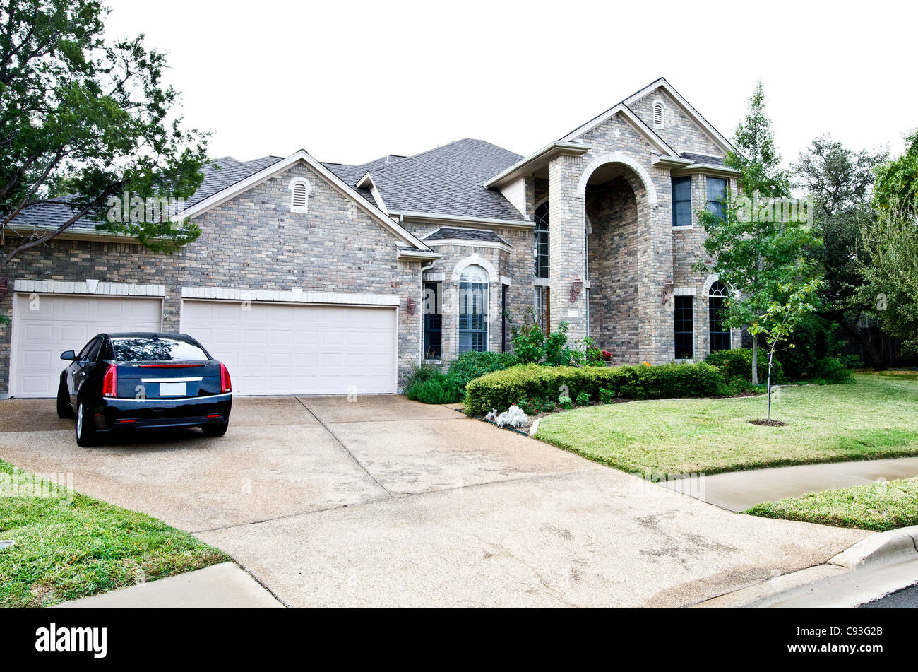 Front view of an upscale house and car in the driveway Stock Photo