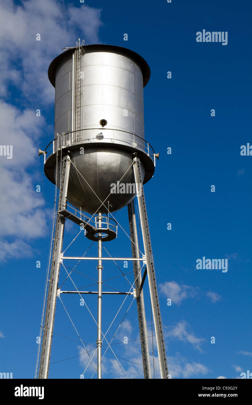 Old retro style water tower that has been restored and painted against a blue sky. Stock Photo