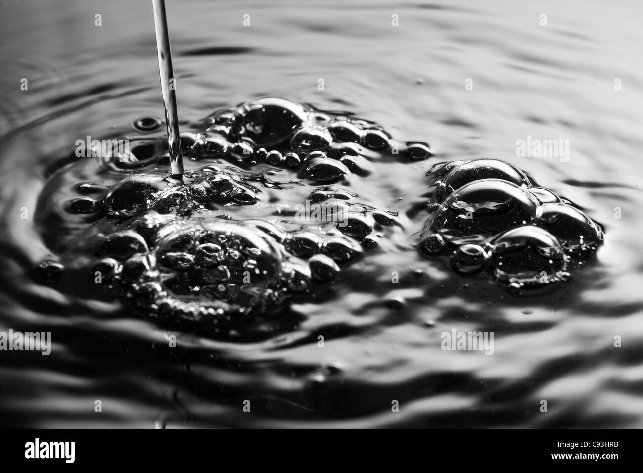 Water being poured into a pool creating bubbles and ripples in the water Stock Photo Alamy