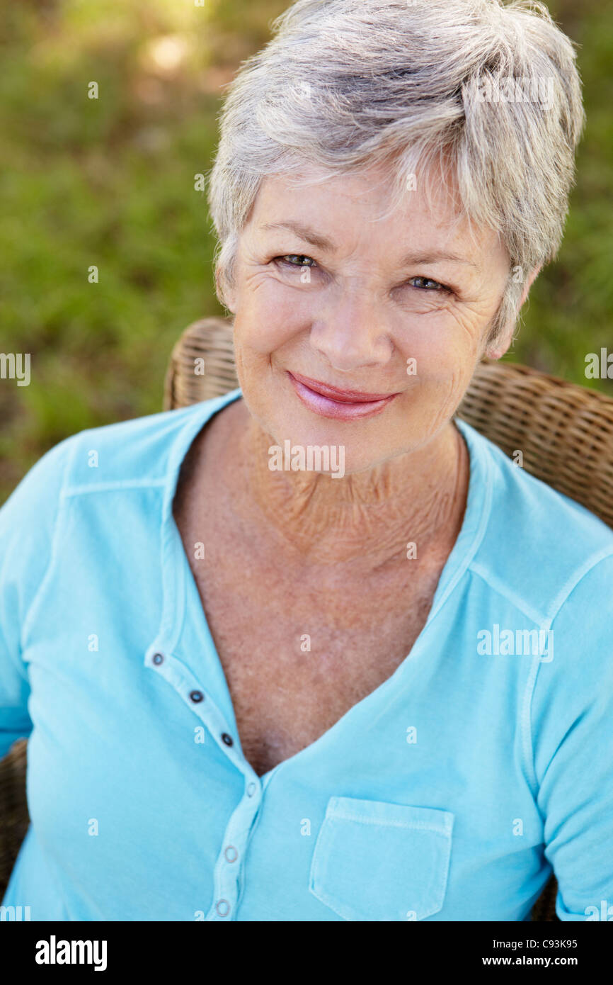 Senior woman sitting outdoors Stock Photo
