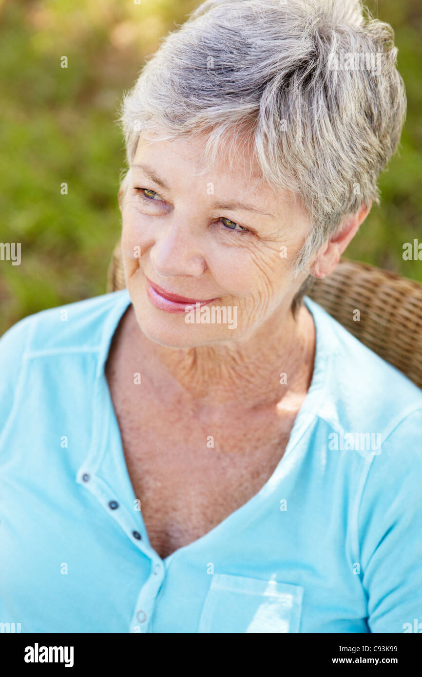 Senior woman sitting outdoors Stock Photo
