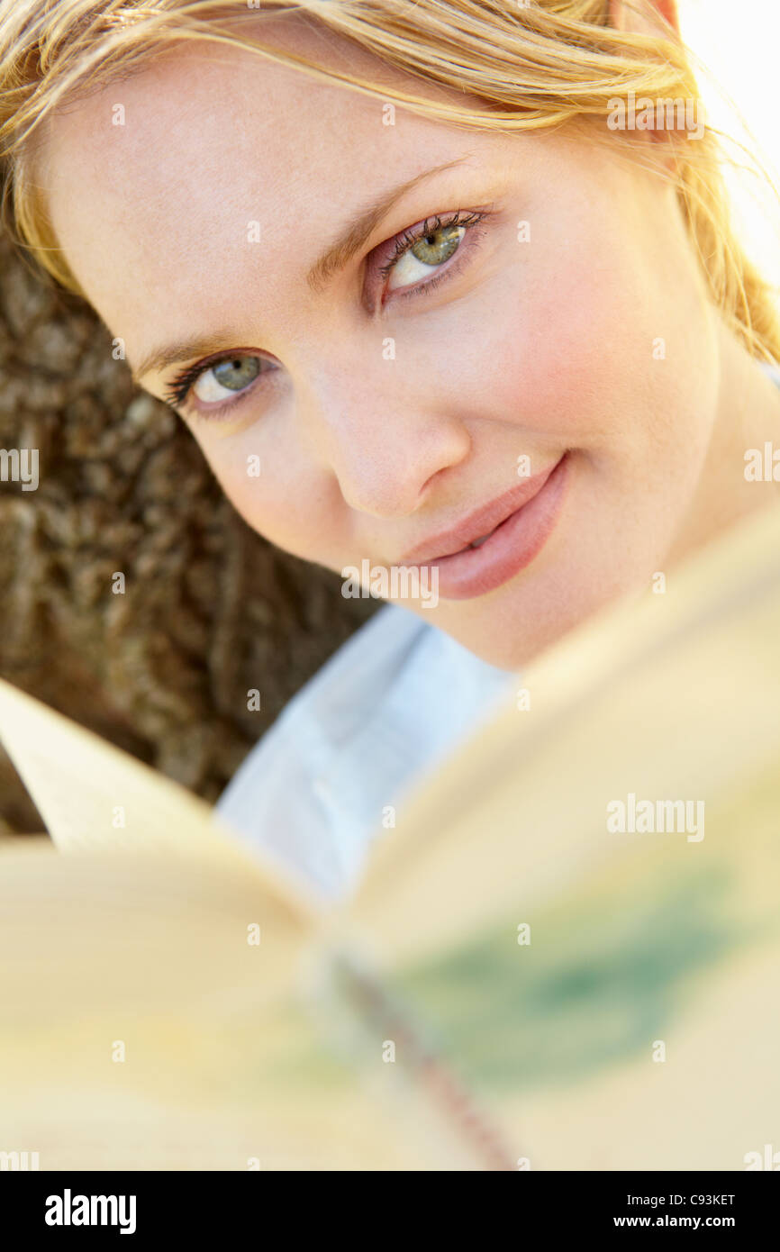 Woman reading book outdoors Stock Photo