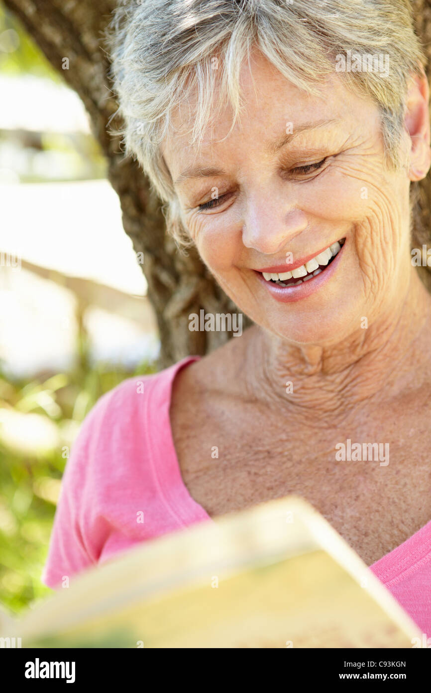 Senior woman reading book outdoors Stock Photo - Alamy