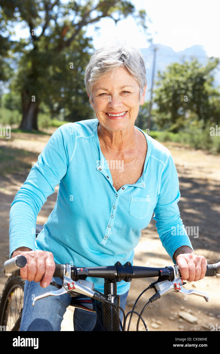 Older woman riding exercise bike hi-res stock photography and images - Alamy