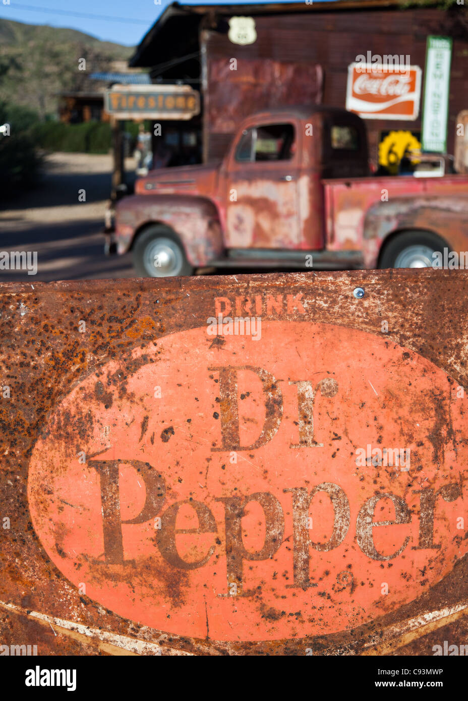 Old rusty Dr Pepper sign in the foreground with a vintage truck in the background outside Hackberry General Store on historic Route 66, Arizona, USA Stock Photo